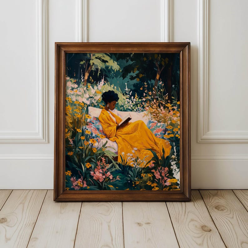 May include: A framed art print depicts a person in a yellow dress reading in a garden. The artwork features a person reclining on a white bench surrounded by colorful flowers and lush greenery. The frame is a warm brown color.