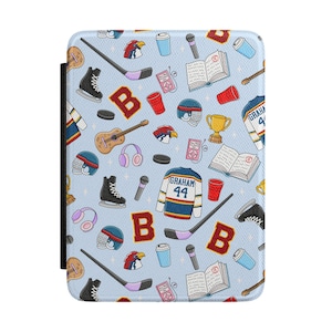 May include: A light blue e-reader case featuring a repeating pattern of hockey sticks, skates, helmets, jerseys with the text GRAHAM 44, guitars, microphones, books with an A grade, red cups, coffee cups, pink headphones, and the letter B.