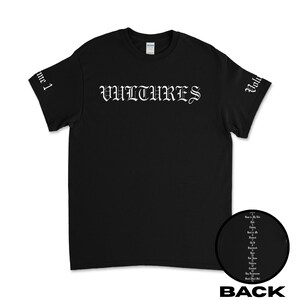 Puede incluir: Camiseta negra con la palabra "VULTURES" impresa en blanco en la parte delantera. Las mangas tienen la palabra "Vulture" impresa en blanco.