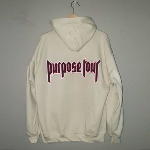May include: A cream coloured hoodie with a red and black "Purpose Tour" graphic on the back.