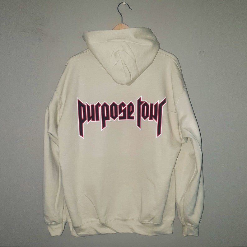 May include: A cream coloured hoodie with a red and black "Purpose Tour" graphic on the back.