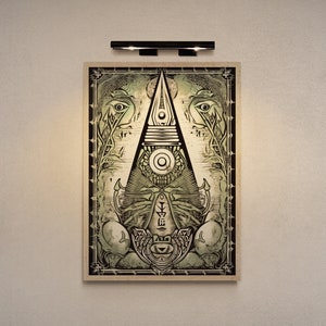 May include: A framed print of a black and white illustration of a geometric design with a central eye. The design is surrounded by a border of stylized leaves and vines. The background is a light beige color.