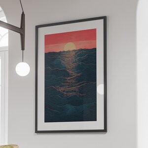 May include: A framed print of a digital illustration of a sunset over a wavy ocean. The sun is a bright orange and the ocean is a dark blue with a pink and orange gradient.