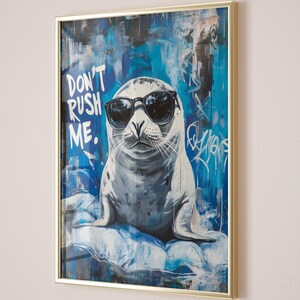 May include: A framed art print featuring a seal wearing sunglasses and a blue and white abstract background. The text "DON'T RUSH ME." is written in white on a black background.
