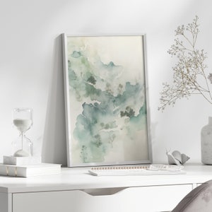 May include: A framed watercolor painting of a landscape with green and blue hues. The painting depicts a misty forest with trees and hills.