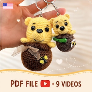 May include: Two handmade crochet keychains featuring yellow bear figures emerging from brown honey pots. One pot has a bow, the other a green ribbon. Each pot has a bee. The text "PDF FILE +9 VIDEOS" is at the bottom.