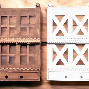 May include: Two wooden wall shelves with a decorative trim. The shelf on the left is stained brown and has a grid pattern. The shelf on the right is painted white and has a criss-cross pattern.