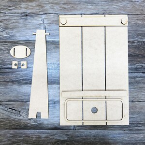 May include: A wooden craft kit for building a miniature easel. The kit includes a small easel, a drawer, and a few small pieces for assembly.