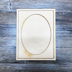 May include: A wooden frame with a cutout oval shape in the center. The frame is light brown and has a simple design.