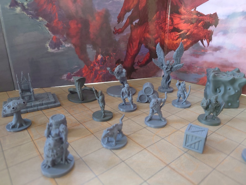 May include: A collection of grey plastic miniature figurines, including a dragon, a tree, a mushroom, a throne, a barrel, a box, and several human and animal figures. The miniatures are arranged on a grey tiled surface.