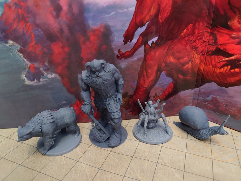 May include: A set of four gray painted miniature figurines, including a dwarf warrior, a bear, a spider, and a snail. The figurines are set on a gray tiled surface.
