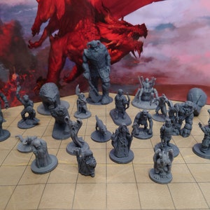 May include: A collection of grey plastic miniature figurines, including a giant, a dragon, a knight, a wizard, and other fantasy creatures. The miniatures are arranged on a gridded surface.