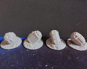 May include: Four unpainted gray resin miniature sci-fi cargo containers, each featuring distinct geometric paneling and ribbed textures, mounted on individual circular textured bases that resemble rocky or cratered terrain.