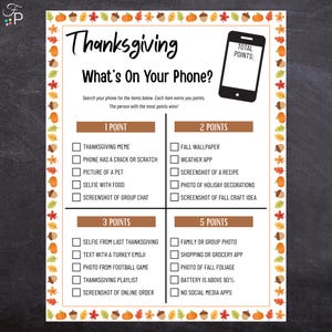May include: Thanksgiving-themed game with the title "What's On Your Phone?" featuring a checklist of items to find on a phone for points. The game has a border of fall leaves, acorns, and pumpkins.