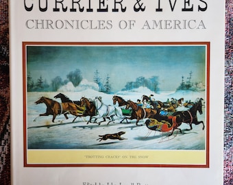 Może przedstawiać: Okładka książki "Currier & Ives Chronicles of America". Przedstawia zimową scenę z końmi ciągnącymi sanie i tekstem "Trotting Cracks on the Snow". Zredagowane przez Johna Lowella Pratta, z wprowadzeniem A. K. Baragwatha.