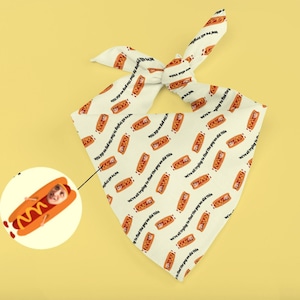 May include: A white bandana with a repeated pattern of a hot dog with a face and the text "We're all trying to find the guy we did this".