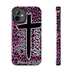 May include: A pink and blue glitter leopard print phone case with a black cross and the text "She is strong" and "Proverbs 31:25".