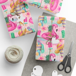 May include: Three pink and white gift wrap sheets with a summer theme. The pattern features pink flamingos, pineapple, popsicles, and beach bags. The gift wrap is tied with twine and has a white star and heart tag.