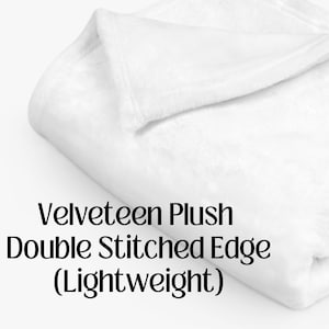 May include: A white, folded, velvety plush blanket with a double stitched edge. The blanket is lightweight.