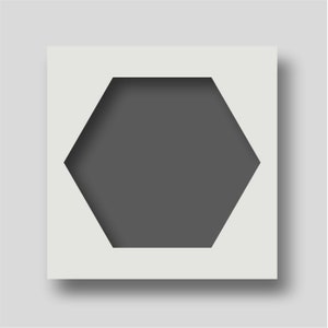Puede incluir: Una tarjeta cuadrada blanca con un recorte hexagonal. El recorte es de color gris oscuro y parece ser un marco para una foto u otra obra de arte.