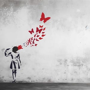 Op de afbeelding: Een stencilkunstwerk op een verweerde witte muur dat een persoon afbeeldt met rode vlinders die uit hun hoofd komen. De vlinders variëren in grootte, met grotere bovenaan, wat een visueel effect creëert.