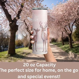 May include: A pink stainless steel tumbler with a white background and a design of two deer. The tumbler has a 20 ounce capacity. The text "20 oz Capacity" is printed below the image. The text "The perfect size for home, on the go, and special events!" is printed below the capacity text.