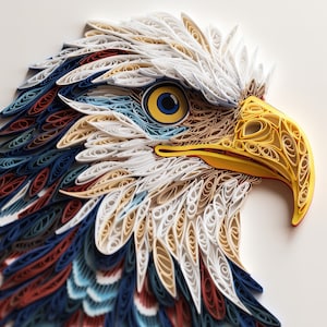 May include: A close-up of a paper quilling art piece depicting a bald eagle's head. The eagle's eye is blue and yellow, and its beak is yellow. The feathers are made of rolled paper in shades of red, white, blue, and brown.