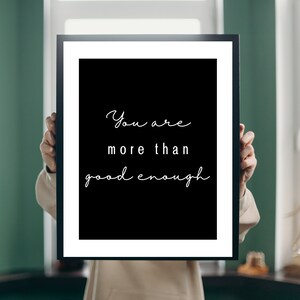 May include: A black and white framed print with the text "You are more than good enough" in a cursive font.