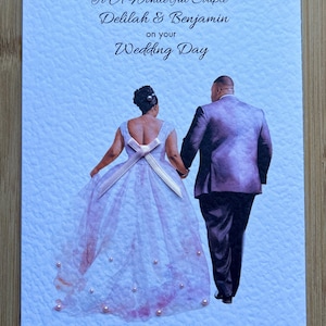 May include: A wedding card with a light blue textured background. The card features an illustration of a couple holding hands, with the text "To A Wonderful Couple Delilah & Benjamin on your Wedding Day" and the date "29th August 2024".