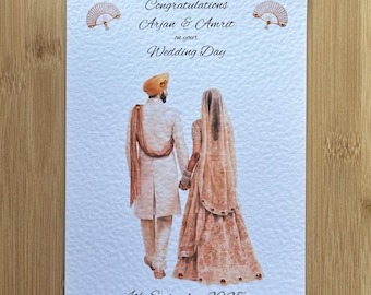 May include: A rectangular wedding card featuring a watercolor illustration of a couple holding hands, wearing traditional attire. The text reads: Congratulations Arjan & Amrit on your Wedding Day, 4th September 2025. Two small fan icons are at the top.