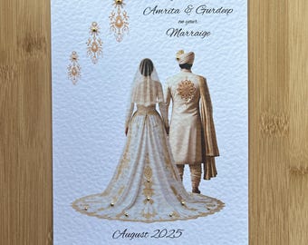 May include: A white wedding greeting card featuring a couple in traditional attire, with the text Congratulations Amrita & Gurdeep on your Marraige and August 2025. The design includes gold foil accents, decorative patterns, and small gold embellishments.