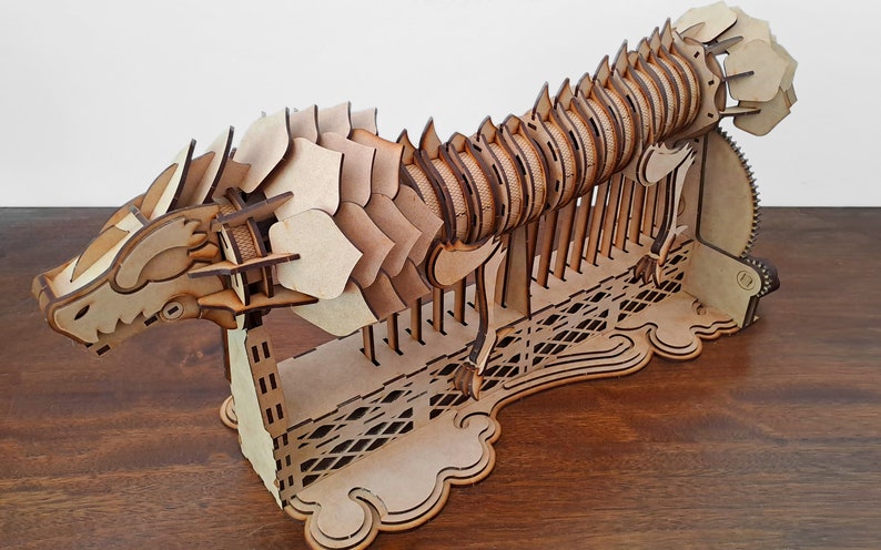 Laser cut dragon automaton model includes assembly manual in Spanish and English image 1