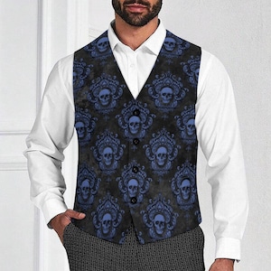 May include: A black vest with a repeating blue skull and floral pattern. The vest has a V-neck and button closure. The vest is worn over a white dress shirt and dark patterned pants.