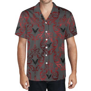 May include: Gray button-up shirt with a red damask pattern and black bat silhouettes. The short-sleeved shirt has a V-neck collar and white buttons. The shirt is made of a lightweight fabric.
