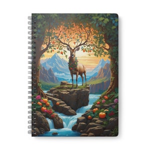 Pode incluir: Um caderno espiral com uma ilustração colorida de um veado em pé em uma rocha com uma cachoeira atrás. O veado tem uma coroa de flores ao redor do pescoço e seus chifres são adornados com frutas. O fundo é uma cordilheira com um céu de pôr do sol.
