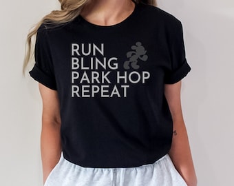 May include: Black t-shirt with a white graphic that says "Run, Bling, Park Hop, Repeat" with a silhouette of Mickey Mouse running.