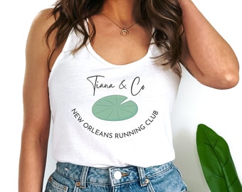 May include: White tank top with a green lily pad graphic and the text "Tiana & Co. New Orleans Running Club".