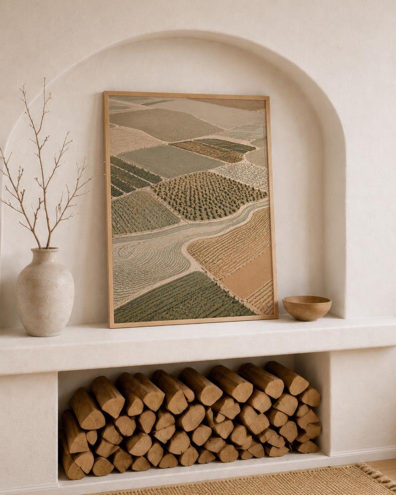 Pode incluir: Uma impress&atilde;o art&iacute;stica retangular emoldurada apresentando uma vista a&eacute;rea de campos agr&iacute;colas em tons de verde s&aacute;lvia, oliva, bege e ocre, separados por caminhos sinuosos. A obra &eacute; exibida em uma moldura fina de madeira clara.