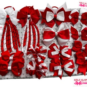 Puede incluir: Una colección de lazos y cintas para el pelo de color rojo y blanco. Los lazos están hechos de cinta de satén y están dispuestos en una variedad de estilos. Las cintas para el pelo están hechas de elástico y están decoradas con cinta roja y blanca. Los lazos y las cintas para el pelo se muestran sobre un fondo blanco con un patrón de corazones.