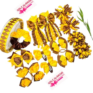 Può includere: Una collezione di accessori per capelli gialli e marroni che include una fascia con motivo, un elastico, diversi fiocchi con clip ed elastici, e grappoli di nastri a spirale. Due cartellini bianchi riportano il testo GIRLS GLAMOUR Accessories.