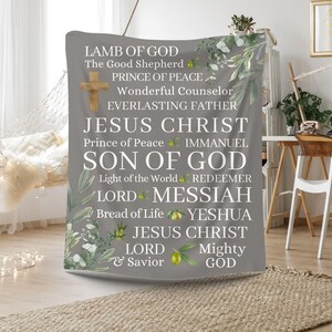May include: A gray tapestry with a white background featuring the names and titles of Jesus Christ, including "Lamb of God", "Prince of Peace", "Son of God", "Lord", "Messiah", and "Jesus Christ". The tapestry is decorated with green leaves and olive branches.