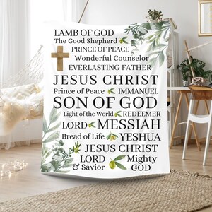 May include: White tapestry with green leaves and olive branches. The tapestry features the text "Lamb of God", "The Good Shepherd", "Prince of Peace", "Wonderful Counselor", "Everlasting Father", "Jesus Christ", "Prince of Peace", "Immanuel", "Son of God", "Light of the World", "Redeemer", "Lord", "Messiah", "Bread of Life", "Yeshua", "Jesus Christ", "Lord", "Mighty", "& Savior", "God".