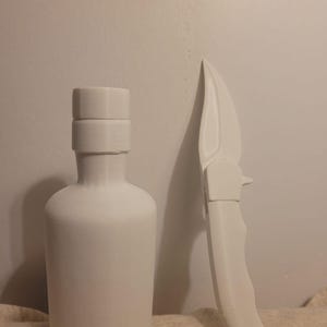 May include: A white, 3D-printed bottle with a cylindrical body and a short neck, next to a white folding knife. The knife has a curved blade and a textured handle. Both items are set against a plain background.