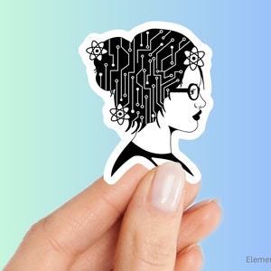May include: A black and white sticker featuring a woman's profile with a circuit board design in her hair and atom symbols. She wears glasses and has dark lipstick. The sticker is held by a hand against a gradient blue and green background.