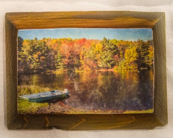 Vermont lake in Autumn with row boat and reflections in the water.