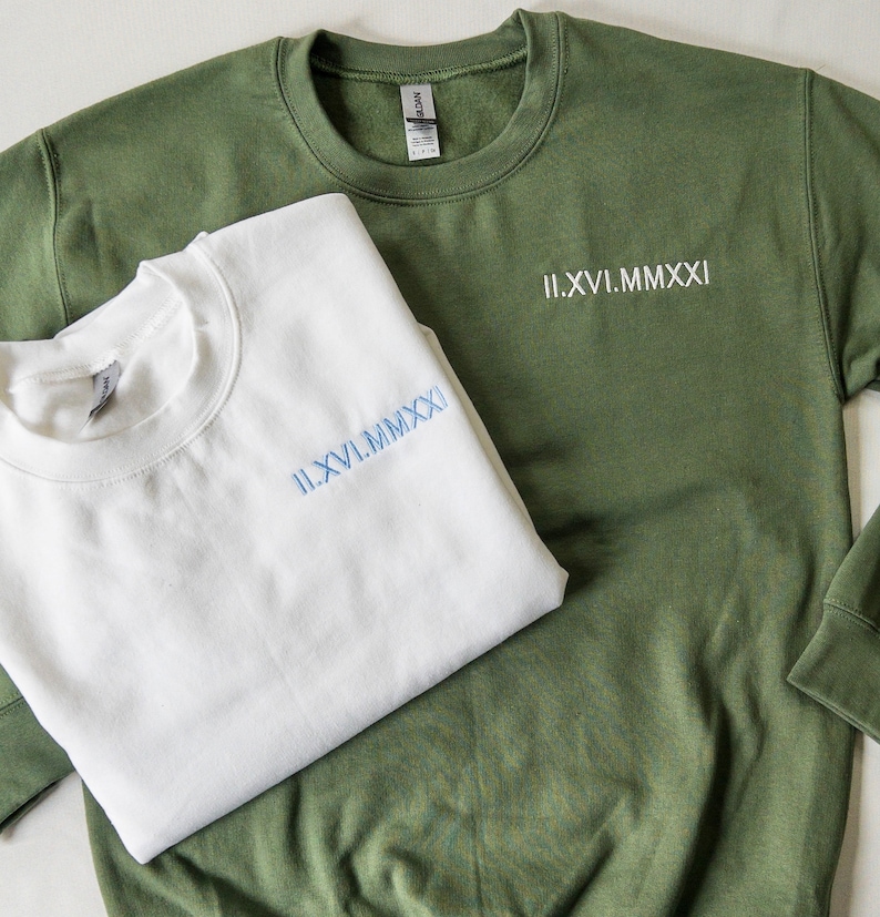 May include: Two sweatshirts, one white and one green, with the same Roman numeral date embroidered on each. The date is II.XVI.MMXXI.