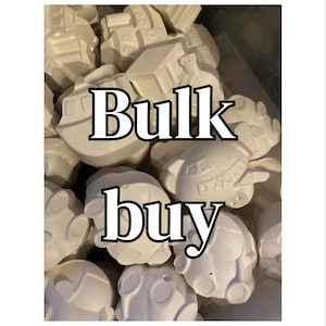 May include: A bulk buy of white ceramic unfinished ornaments shaped like cars and airplanes. The ornaments are ready to be painted.
