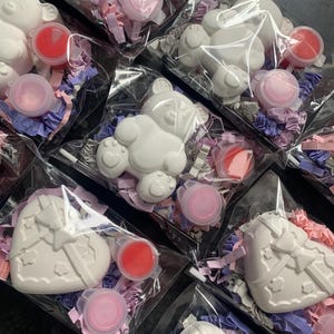 Peut inclure: Plusieurs sacs en plastique transparents contenant chacun une figurine en plâtre blanc en forme d'ours ou de cœur, de petits pots de peinture roses et rouges, et des confettis décoratifs roses et violets. Articles emballés pour la vente.