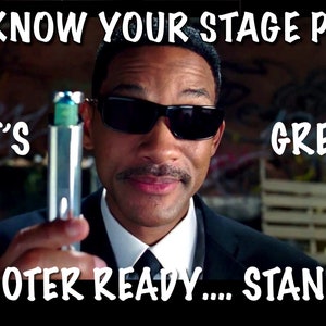 Puede incluir: Un hombre con gafas de sol y traje sostiene un objeto plateado con una parte superior azul y verde. El texto "YOU KNOW YOUR STAGE PLAN... THAT'S GREAT SHOOTER READY... STANDBY" está escrito en la imagen.