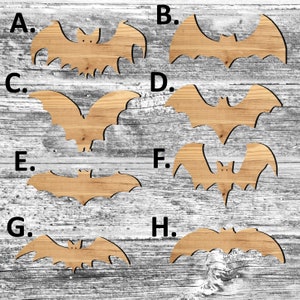 May include: Eight wooden bat cutouts in various sizes and shapes, labeled with letters A through H. The bat cutouts are arranged in two rows of four on a woodgrain background.